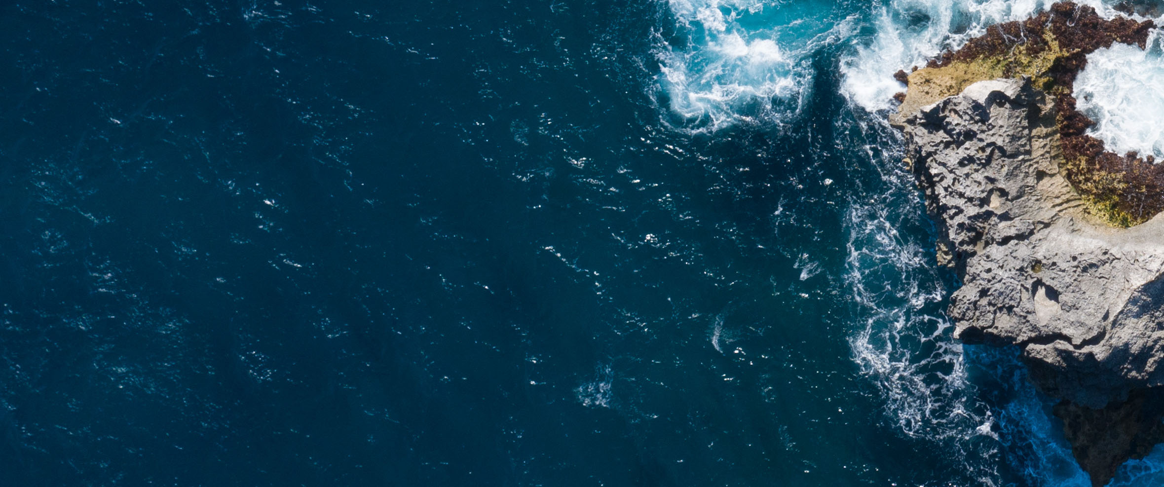 Aerial drone view of a seaside cliff, blue lagoon